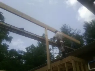 Carpenter setting a ridge beam over a new addition frame — Ice Dam Removal by Roofing Brothers in Freehold