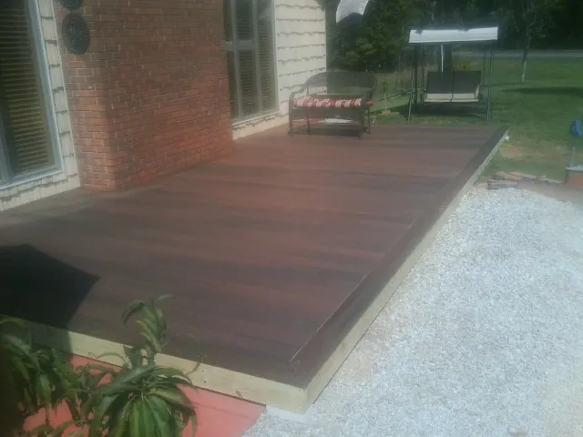 Freshly stained wood deck built against a brick home in Freehold