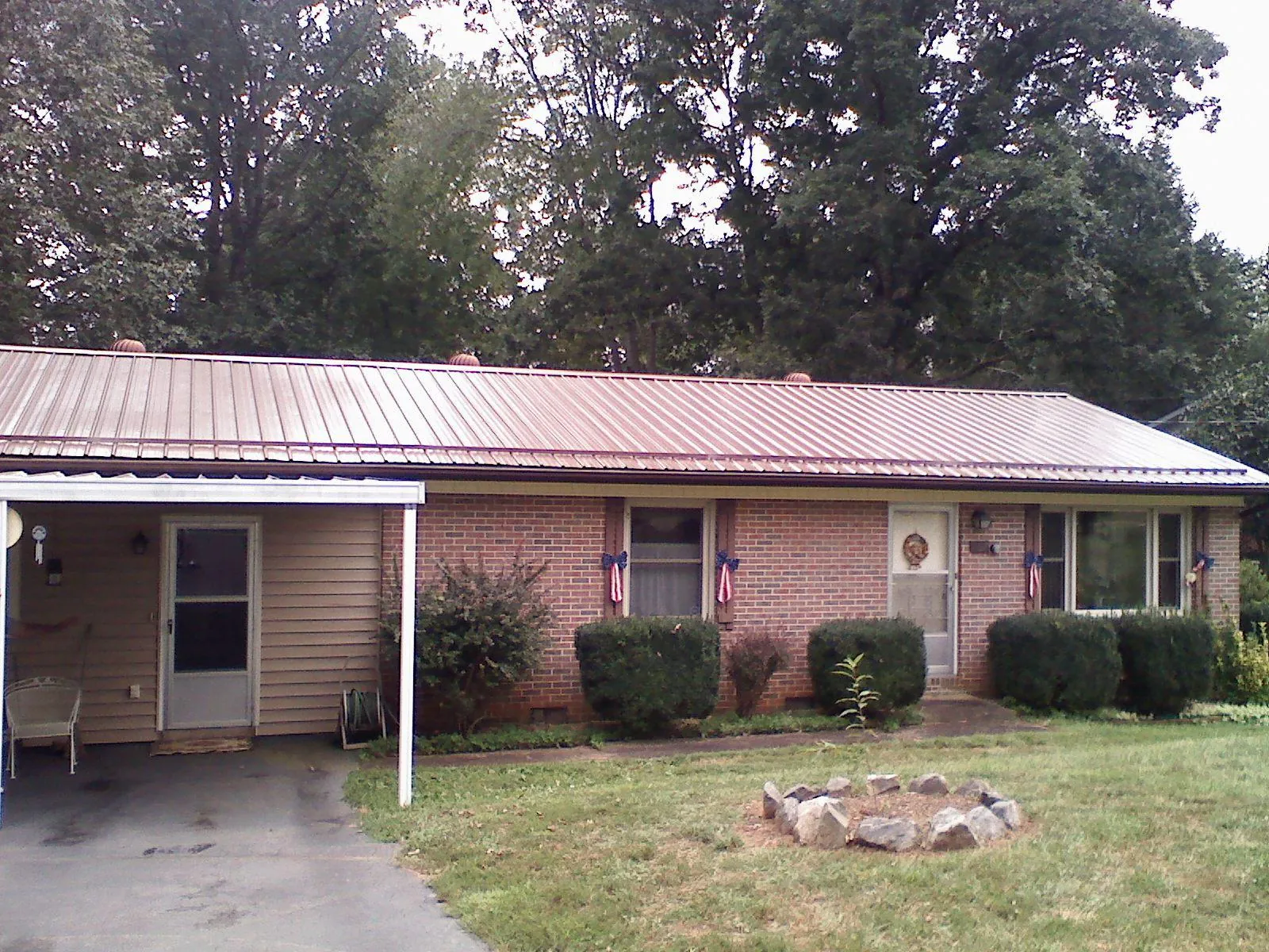 Bronze metal roof and carport on a brick ranch home — Roof Repair work by our crew in Freehold